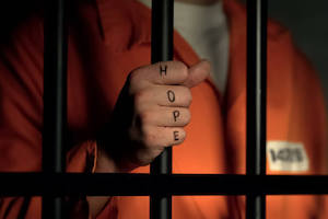 Prisoner in jail cell with hope tattoo