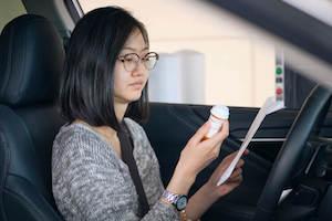 Driver looks at prescription drug bottle
